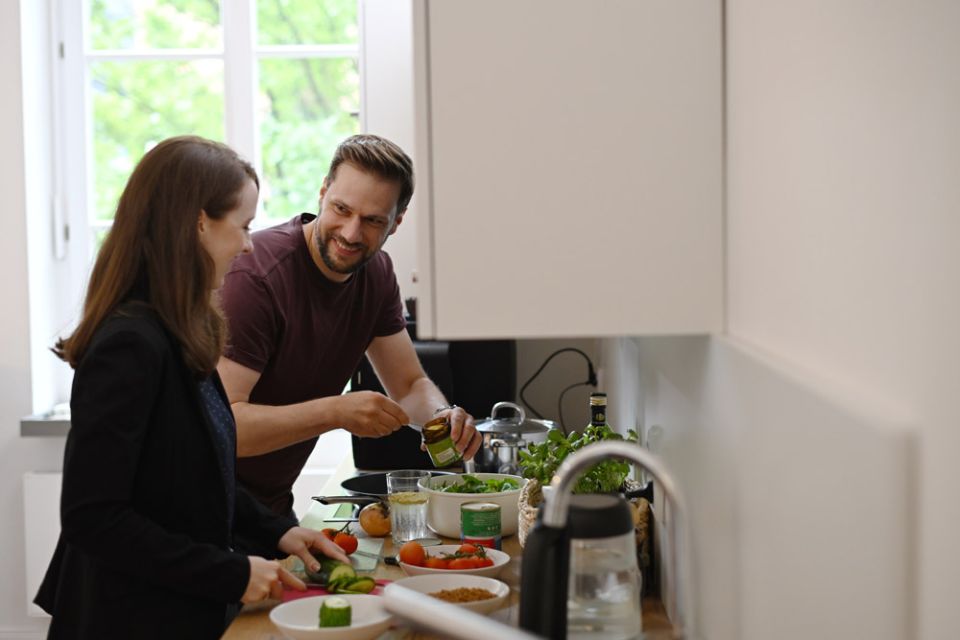 Zwei Personen stehen in der Küche und bereiten Essen vor