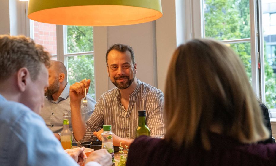 Mehrere Personen sitzen beim Mittagessen an einem Tisch