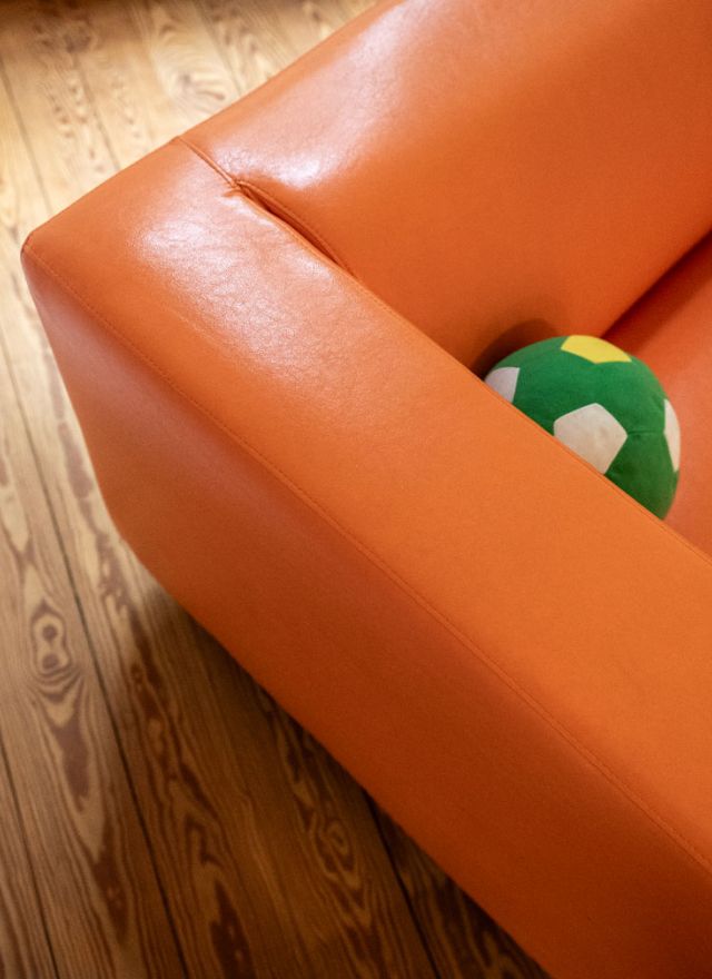 Ein Ball in der Ecke eines orangenen Sofas