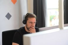 Eine Person mit Headset vor einem Computer