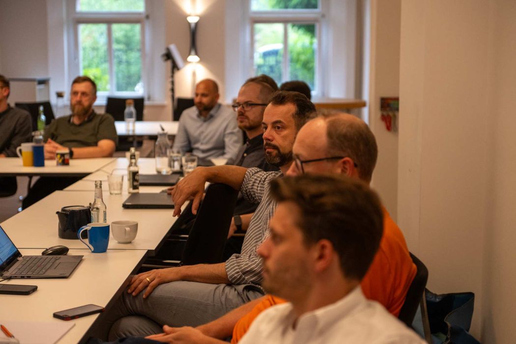 Mehrere Personen sitzen an einem Konferenztisch